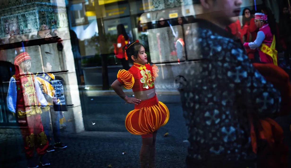 Seorang anak mengenakan pakaian tradisional China saat perayaan menjelang tahun baru China di Lisbon, Portugal (21/1). Perayaan tahun baru Imlek merupakan salah satu hari besar yang dirayakan oleh kaum Tionghoa. (AFP/Patricia De Melo Moreira)
