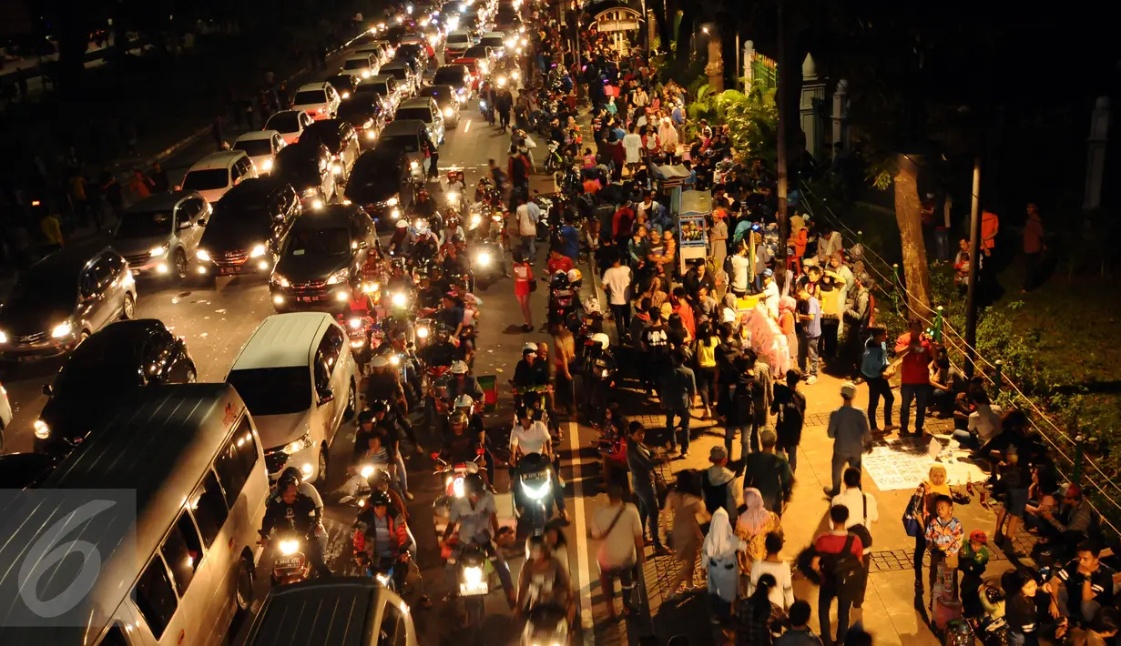 Pejalan kaki memadati pedestrian pasca perayaan malam pergantian tahun di Jalan Medan Merdeka Barat, Jakarta, Minggu (1/1). Ribuan warga merayakan malam pergantian tahun di sekitar kawasan Monas dan bundaran air mancur. (Liputan6.com/Helmi Fithriansyah)