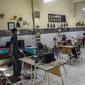 Siswa mengikuti pembelajaran tatap muka (PTM) di sebuah sekolah di Surabaya, Jawa Timur, Senin (6/9/2021). Pemerintah kembali membuka sekolah di tengah pandemi COVID-19. (JUNI KRISWANTO/AFP)