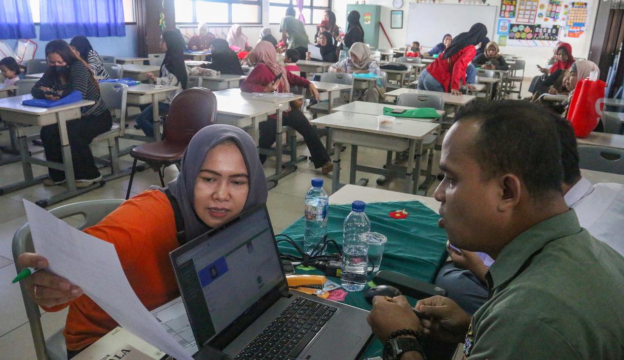 Kegiatan ini bagian upaya jemput bola yang dilakukan Suku Dinas Dukcapil Jakarta Selatan mendekatkan pelayanan kepada masyarakat. Tampak dalam foto, salah satu orang tua murid mengecek dokumen saat pelaksanaan program Layanan Anak Sekolah Suku Dinas Kependudukan dan Pencatatan Sipil (Dukcapil) Jakarta Selatan (Laksana Sultan) di Sekolah Dasar Negeri (SDN) Kebagusan 01, Pasar Minggu, Jakarta, Senin (4/5/2026). (merdeka.com/Arie Basuki)