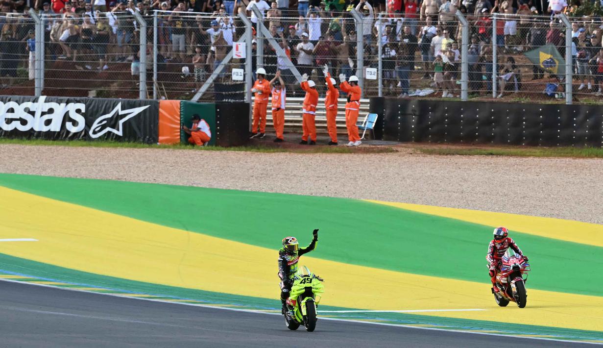 Kemenangan ini sekaligus membuat Marc Marquez menyamai rekor kemenangan Sprint terbanyak milik Jorge Martin, yakni 16 Sprint. Tampak dalam foto, pembalap Pertamina Enduro VR46 Racing Team asal Italia, Fabio Di Giannantonio (kiri) melambaikan tangan di samping Marc Marquez (Ducati Lenovo Team), di akhir Sprint Race MotoGP Brasil 2026 di Autodromo Internacional Ayrton Senna, Goiania, Sabtu 21 Maret 2026 waktu setempat atau Minggu (22/3/2026) dini hari WIB. (EVARISTO SA/AFP)