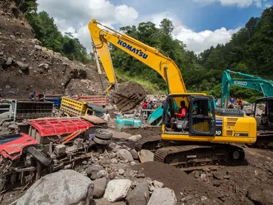Beberapa alat berat dikerahkan untuk mengevakuasi puluhan truk yang terkubur di pasir setelah longsor lumpur akibat hujan dari Gunung Merapi di Sungai Senowo, Magelang, Jawa Tengah pada Rabu 4 Maret 2026. Banjir lahar dingin dari Gunung Merapi menerjang Sungai Senowo di Kabupaten Magelang, Jawa Tengah. (Devi Rahman/AFP)