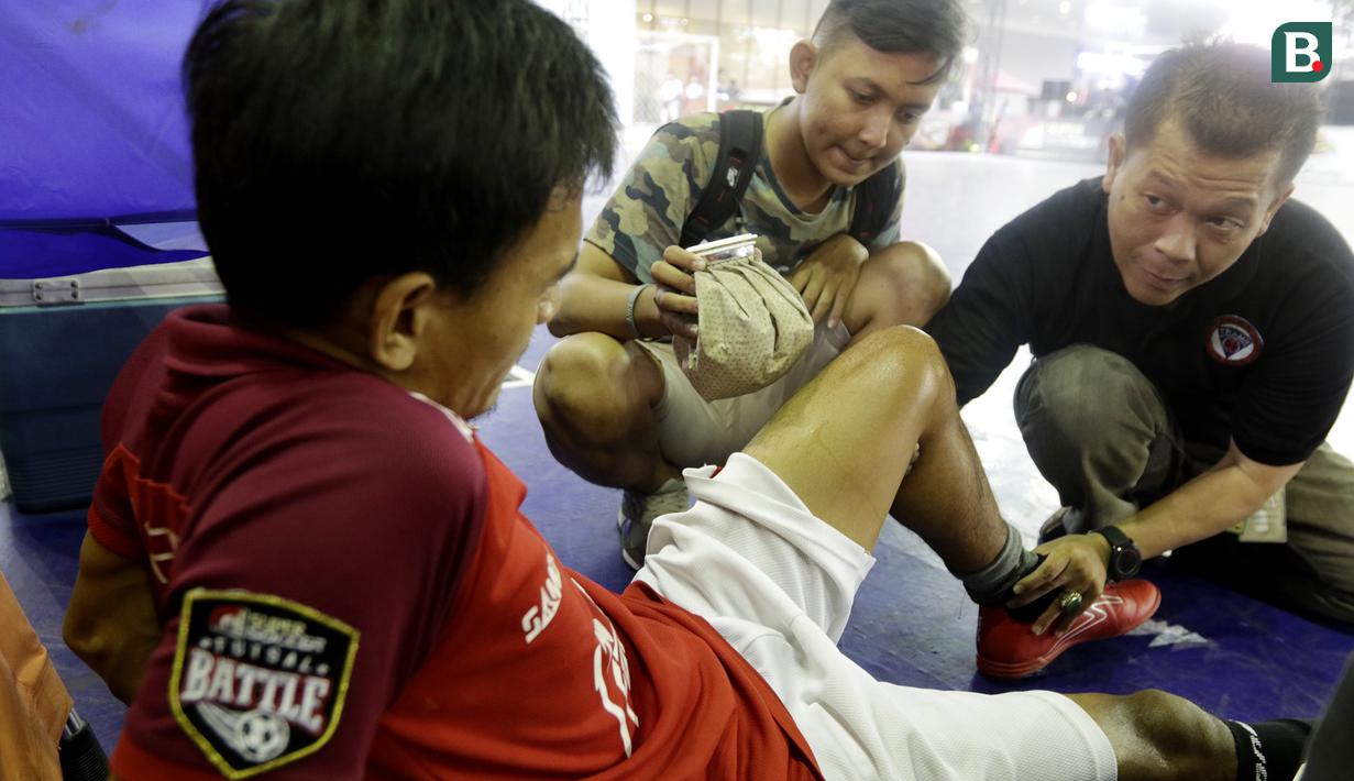 Tim medis memberikan bantuan kepada pemain Surya Futsal yang cedera saat melawan Doby MCW Banten pada laga Super Soccer Futsal Battle di Summarecon Mall Serpong, Sabtu (29/09/2018). Doby MCW Banten takluk 2-8 dari Surya Futsal. (Bola.com/M Iqbal Ichsan)