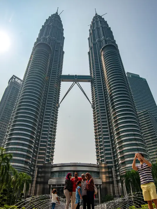 Sejumlah orang memotret di depan Menara Kembar Petronas, Kuala Lumpur, Malaysia, 18 Maret 2016. Kombinasi antara gedung pencakar langit dan situs bersejarah serta perpaduan harmonis beragam budaya semakin memperkaya pesona khas dari Kuala Lumpur. (Xinhua/Chong Voon Chung)