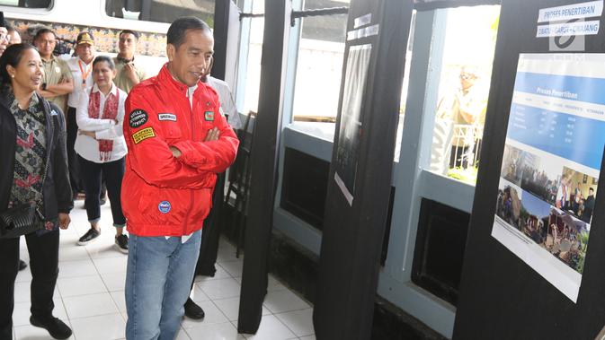Presiden Joko Widodo melihat-lihat papan yang berisi penjelasan mengenai reaktivasi jalur kereta api di Stasiun Cibatu, Garut, Jawa Barat, Jumat (18/1). Dalam kunjungan kerja ini, Jokowi didampingi Ibu Negara Iriana Joko Widodo (Liputan6.com/Angga Yuniar)