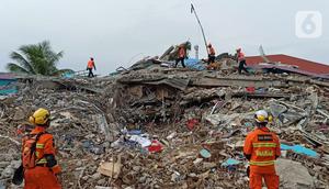 Anjing polisi K-9 mengendus bangunan yang runtuh akibat gempa bumi saat proses pencarian korban di Rumah Sakit Mitra Manakarra di Mamuju, Minggu (17/1/2021). Polri mengerahkan enam ekor K-9 untuk membantu menangani dampak gempa di Majene dan Mamuju, Sulawesi Barat. (Liputan6.com/Abdul Rajab Umar)