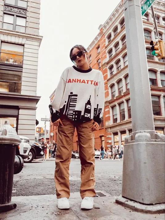 Kali ini, dengan sweater bertuliskan Manhattan, Beby Tsabina tampil kasual. Beby Tsabina memadukan penampilannya dengan celana panjang cokelat, sneakers putih, dan tak lupa sunglasses. Foto: Instagram.