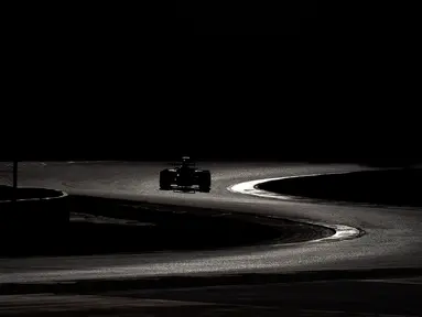 Siluet mobil pebalap Toro Rosso, Max Verstappen, saat beraksi dalam hari ketiga tes pramusim F1 di Sirkuit Catalunya, Barcelona, Spanyol, (3/3/2016). (AFP/Josep Lago)