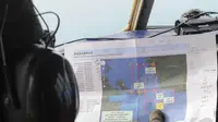 Seorang awak pesawat mengamati peta rencana pergerakan Basarnas saat melakukan pencarian pesawat AirAsia QZ8501, Senin (29/12/2014). (Liputan6.com/Herman Zakharia)