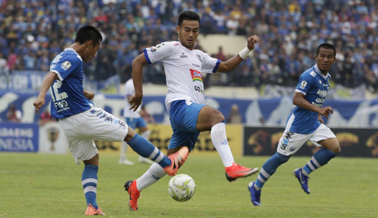 Gelandang Arema Malang, Muhammad Rafli, berusaha menghalau bola saat melawan Persib Bandung pada laga Piala Indonesia di Stadion Si Jalak Harupat, Bandung, Senin (18/2). Persib bermain imbang 1-1 melawan Arema. (Bola.com/Vitalis Yogi Trisna)