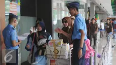 Petugas memeriksa kecocokan tiket calon penumpang pesawat di Bandara Halim Perdanakusuma Jakarta, Senin (4/7). H-2 jelang Idul Fitri 1437 H, ribuan calon penumpang diberangkatkan dari Bandara Halim Perdanakusuma. (Liputan6.com/Helmi Fithriansyah)
