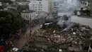 Petugas pemadam kebakaran saat berupaya membersihkan reruntuhan bangunan yang hancur akibat ledakan yang terjadi Rio de Janeiro, Brasil, Senin (19/10/2015). Petugas masih mecari korban - korban yang terjebak dalam reruntuhan. (REUTERS/Pilar Olivares)