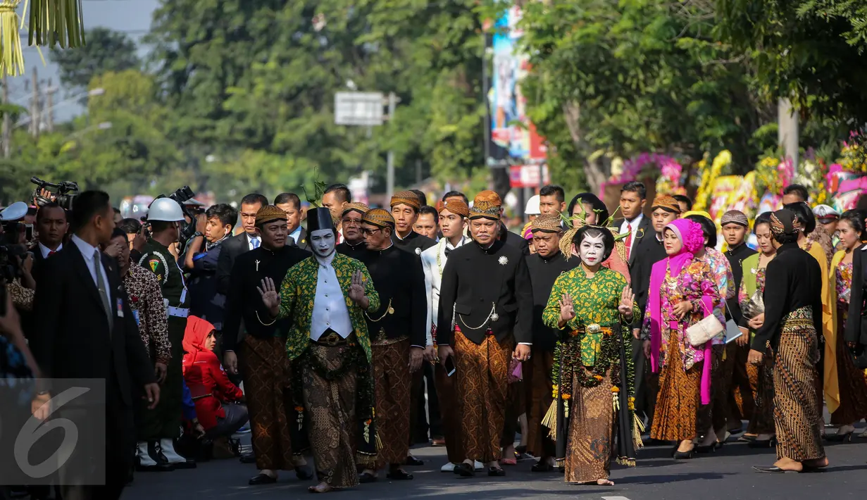 Rombongan Gibran Rakabuming Raka diiringi tari "Edan-edanan" yang dilakukan sepasang penari saat berjalan kaki menuju lokasi akad nikah, di Gedung Graha Buana, Solo, Jawa Tengah, Kamis (11/6/2015). (Liputan6.com/Faizal Fanani)