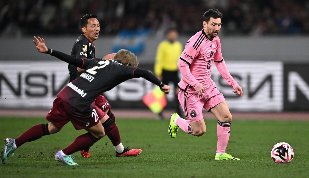 Pemain Inter Miami, Lionel Messi (kanan) menggiring bola melewati sejumlah pemain Vissel Kobe pada laga persahabatan di National Stadium, Tokyo, Jepang, Rabu (07/02/2024). (AFP/Philip Fong)
