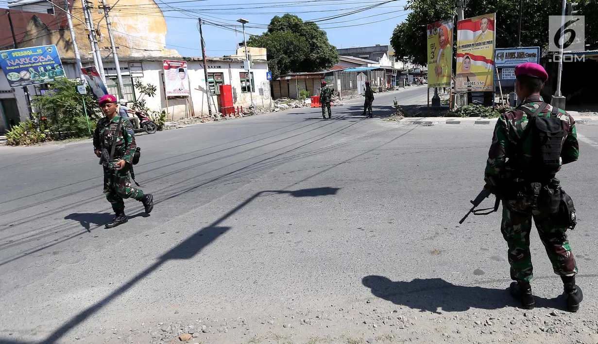Prajurit Marinir TNI Angkatan Laut berjaga di perempatan lampu merah kota Palu pasca gempa dan tsunami di Palu, Sulawesi Tengah, Jumat (5/10). TNI kembali mengirimkan pasukan untuk memulihkan Kota Palu. (Liputan6.com/Fery Pradolo)
