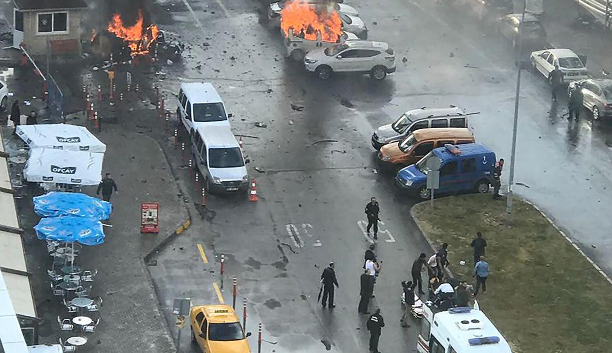 Sejumlah mobil terbakar setelah ledakan terjadi di luar sebuah pengadilan di kota Izmir, wilayah barat Turki, Kamis (5/1). Sedikitnya 10 orang terluka akibat kejadian ini. (DHA/Dogan News Agency/AFP)