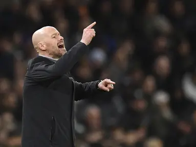 Pelatih Manchester United, Erik Ten Hag memberikan instruksi kepada para pemain dalam pertandingan leg kedua play-off babak gugur Liga Europa 2022/2023 antara Manchester United melawan Barcelona yang berlangsung di Old Trafford, Jumat (24/2/2023) WIB. Perubahan strategi Erik Ten Hag dengan memasukkan Anthony di babak kedua membuahkan hasil manis bagi kemenangan MU. (AFP/Oli Scarff)