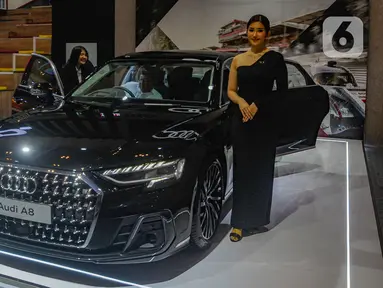 Model berdiri di samping mobil mewah Audi A8 seharga Rp 3,2 miliar pada pameran otomotif GAIKINDO Indonesia International Auto Show (GIIAS) 2024 di Indonesia Convention Exhibition (ICE) BSD Tangerang, Banten, Jumat (19/7/2024). (merdeka.com/Arie Basuki)