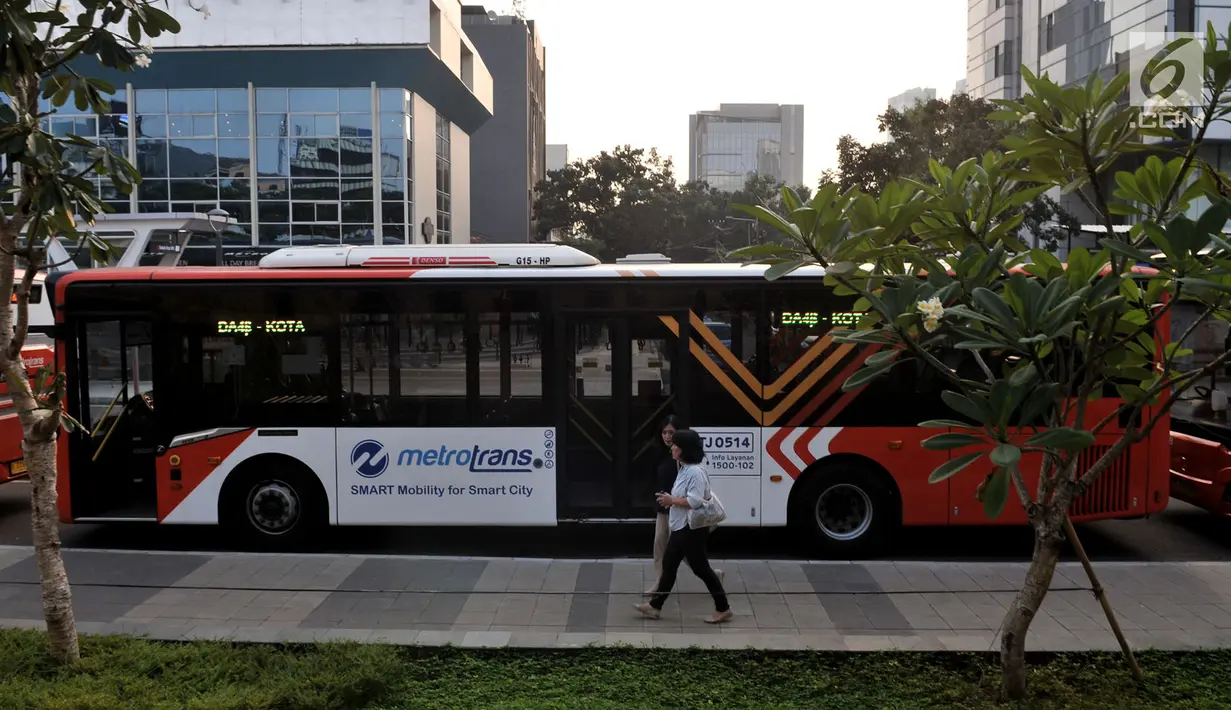 Pejalan kaki berjalan di dekat bus Transjakarta di Kawasan Terintegrasi Transportasi Dukuh Atas, Jakarta, Rabu (12/6/2019). PT Transjakarta mencatat adanya peningkatan penumpang setelah Moda Raya Terpadu (MRT) beroperasi. (merdeka.com/Iqbal S. Nugroho)