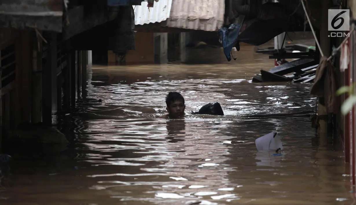 Warga melintasi banjir di Jalan Kebon Pala, Kampung Melayu, Jatinegara, Jakarta Timur, Rabu (7/2). Setelah sempat surut, banjir kembali merendam permukiman warga dengan ketinggian air mencapai sekitar 170 cm. (Liputan6.com/Arya Manggala)