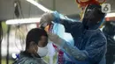 Tukang cukur mengenakan alat pelindung diri (APD) dari plastik saat mencukur rambut pelanggan di Pondok Kelapa, Jakarta, Selasa (5/5/2020). Tukang cukur mengenakan APD untuk mengurangi risiko penularan virus corona COVID-19. (merdeka.com/Imam Buhori)