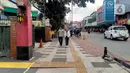 Pejalan kaki melintasi jalur pedestrian sepanjang Jalan Surya Kencana, Kota Bogor, Jawa Barat, Sabtu (3/12/2022). Jalur pedestrian yang seharusnya menjadi akses pejalan kaki dan ramah bagi kaum disabilitas itu tidak berfungsi dengan semestinya. (Liputan6.com/Magang/Aida Nuralifa)