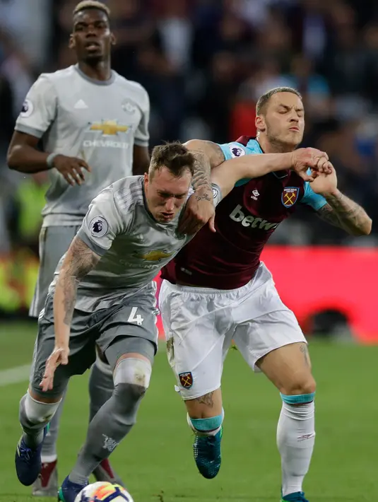 Pemain West Ham United Marko Arnautovic berebut bola dengan pemain Manchester United Phil Jones saat pertandingan Liga Inggris di London Stadium di London (10/5). (AP Photo / Alastair Grant)