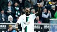 Pemain Borussia Moenchengladbach, Marcus Thuram, melakukan selebrasi saat melawan Bayern Munchen pada laga Liga Jerman (18/2/2023). Marcus Thuram tampil moncer bersama Borussia Monchengladbach dengan mengoleksi 16 gol dan lima assist musim ini. Mu bisa memboyong sang pemain ke Old Trafford lantaran kontraknya bersama Monchengladbach akan berakhir pada akhir Juni 2023. (AFP/Ina Fassebender)