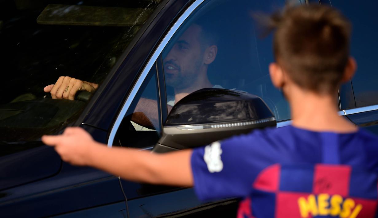 Seorang bocah saat menunggu Lionel Messi di lokasi latihan Barcelona, Senin (31/8/2020). Messi secara mengejutkan tidak datang untuk mengikuti tes swab Covid-19 yang dijadwalkan Barcelona. (AFP/Pau Barrena)