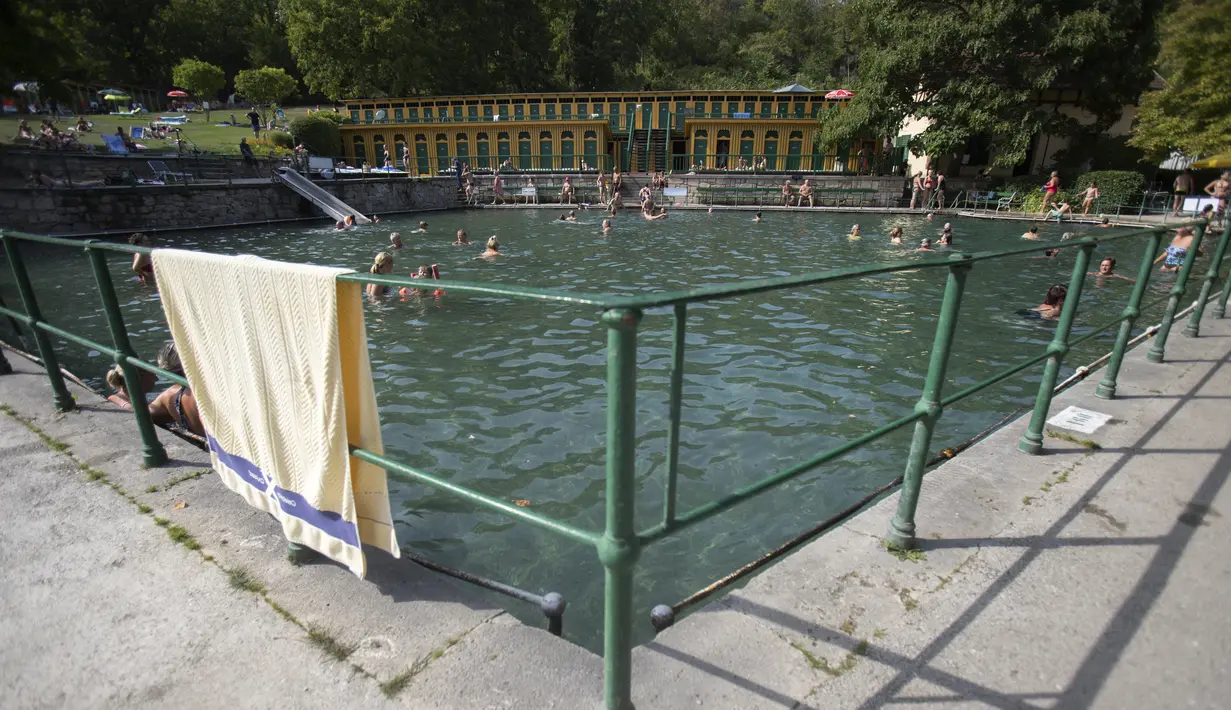 Orang-orang berenang di kolam utama di pemandian air panas Bad Fischau, 50 km selatan Wina, di Bad Fischau, Austria Bawah, pada 18 Agustus 2022. Pemandian air panas Belle Epoque Bad Fischau yang terkenal harus menutup beberapa kolam karena beberapa mata air yang memasoknya telah mengering karena kekeringan di tengah perubahan iklim. (Alex HALADA / AFP)