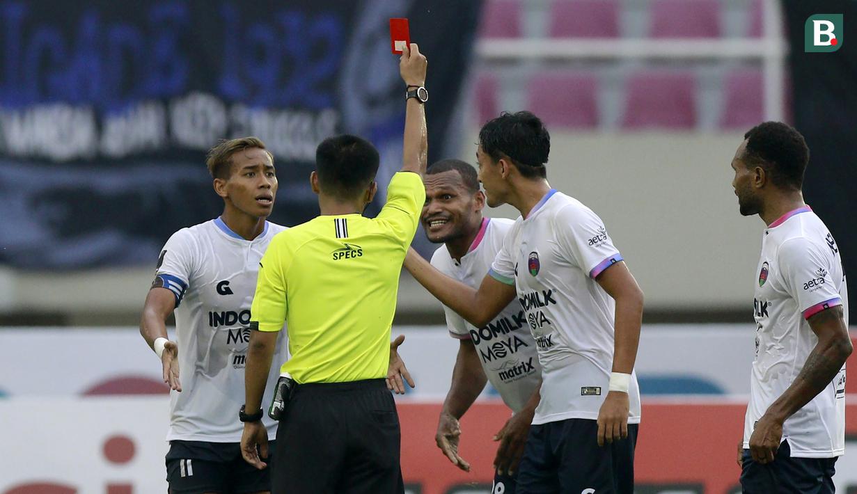 Wasit Darma Santoso Gulo memberikan kartu merah kepada pemain Persita Tangerang, Israel Wamiau (kedua dari kanan) usai melanggar pemain PSIS Semarang dalam lanjutan pertandingan babak penyisihan Grup A Piala Presiden 2022 antara PSIS Semarang menghadapi Persita Tengerang di Stadion Manahan, Solo, Jawa Tengah, Senin (13/6/2022). (Bola.com/Arief Bagus)