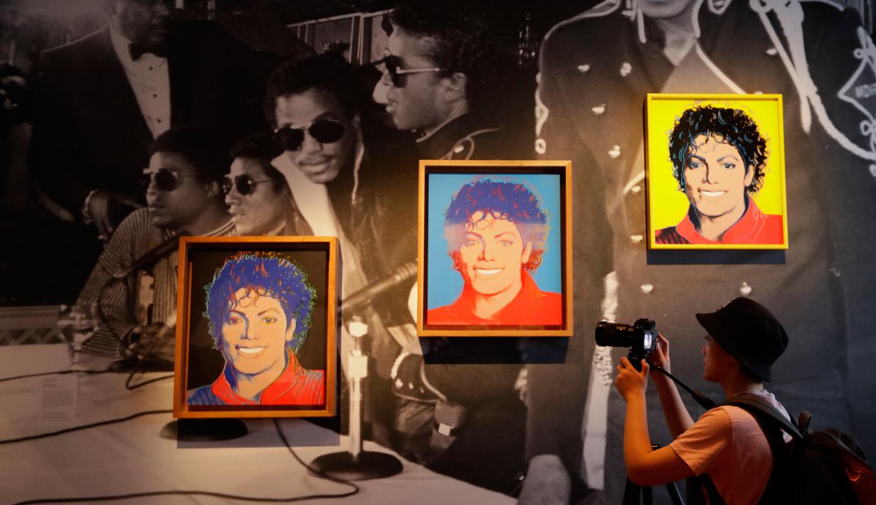 Pengunjung mengambil gambar karya seni seniman AS, Andy Warhol pada pameran 'Michael Jackson: On The Wall' di National Potrait Gallery, London, Rabu (27/6). Pameran ini memperingati ulang tahun Michael Jackson pada 29 Agustus. (AP/Kirsty Wigglesworth)