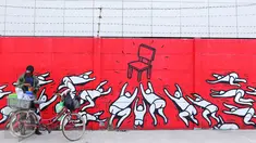 Warga berjualan di depan mural bernuansa politik di Penjaringan, Jakarta, Minggu (7/8). Jelang Pilkada 2017, sejumlah lokasi di Jakarta dihiasi mural politik. (Liputan6.com/Angga Yuniar)