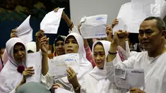 Calon jemaah umrah First Travel menunjukkan kwitansi saat mendatangi gedung DPR bertemu dan mengadu ke Komisi VIII DPR Fraksi PPP, di Kompleks Parlemen, Senayan, Jakarta, Jumat (18/8). (Liputan6.com/Johan Tallo)