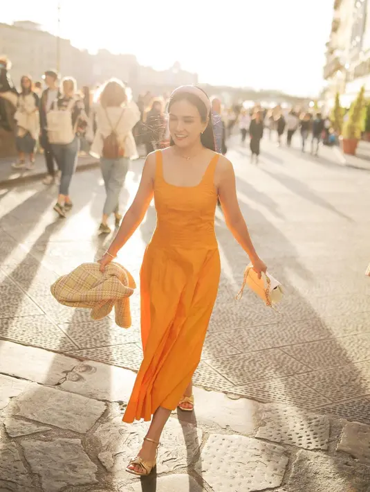 Shandy Aulia tampil cantik dibalut dress tanpa lengan berwarna mustard. OOTD yang pas jika kamu berlibur ke daerah tropis atau hangat. [Foto: Instagram/shandyaulia]