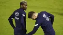 Gelandang Prancis Paul Pogba dan penyerang Olivier Giroud berbicara selama sesi latihan di Clairefontaine-en-Yvelines, Paris, Selasa (10/11/2020). Prancis akan melawan Finlandia di Stade de France pada Kamis (12/11) dini hari WIB dalam pertandingan persahabatan internasional. (Yoan VALAT/POOL/AFP)