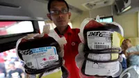 Seorang petugas memperlihatkan darah yang berhasilkan didonorkan dari peserta Dance4life di Bundaran HI, Jakarta, Minggu (7/12/2014). (Liputan6.com/Miftahul Hayat)