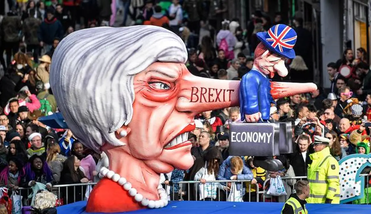 Karakter yang menggambarkan Perdana Menteri Inggris Theresa May dengan hidung panjang bertulis 'brexit' memeriahkan Karnaval Rose Monday di Duesseldorf, Jerman, Senin (4/3). (AP Photo/MartinMeissner)