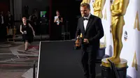 Aktor Leonardo DiCaprio berpose memegang piala oscar di belakang panggung selama 88 Academy Awards di Hollywood, California (28/2/2016). (REUTERS /Mike Blake)