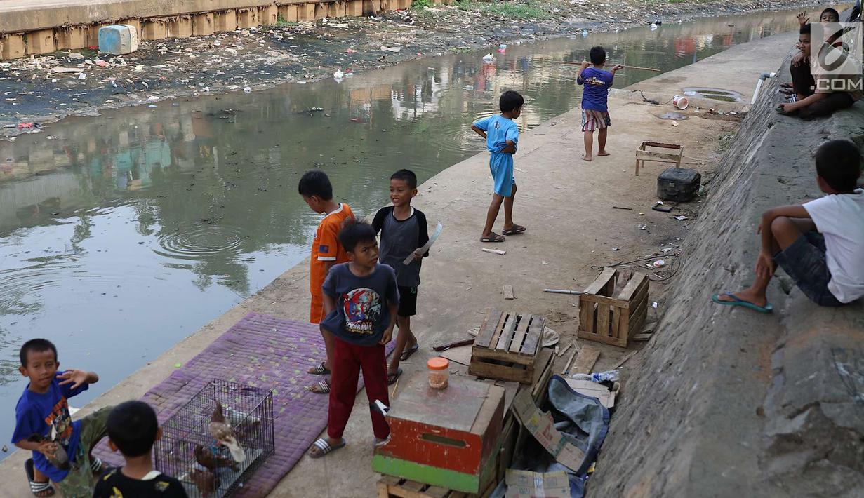 Anak-anak bermain di bantaran anak Sungai Ciliwung, Jakarta, Rabu (6/6). Meskipun tidak layak sebagai tempat bermain, namun lokasi itu menjadi tempat bagi anak-anak di kawasan tersebut untuk menunggu waktu berbuka. (Liputan6.com/Immanuel Antonius)