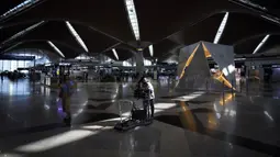 Pelancong mendorong barang bawaannya untuk check-in di Bandara Internasional Kuala Lumpur, Sepang, Malaysia, Jumat (1/4/2022). Mulai hari ini, Malaysia membuka perbatasannya untuk orang asing dan pelancong yang sudah divaksin COVID-19 lengkap tanpa harus menjalani karantina. (AP Photo/Vincent Thian)
