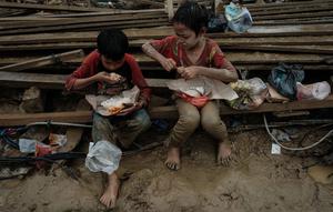 Anak-anak memakan makanan yang dibagikan di Babo, Aceh Tamiang, pada Senin 15 Desember 2025. Ancaman gangguan kesehatan menghantui anak-anak korban bencana banjir bandang dan tanah longsor yang terjadi di berbagai wilayah di Aceh, Sumatera Utara, dan Sumatera Barat. (Yasuyoshi CHIBA/AFP)