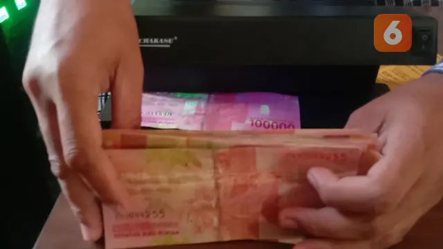 Benang Pengaman Uang Palsu Dibawah Sinar Ultraviolet. (Rabu, 28/09/2022). (Yandhi Deslatama/Liputan6.com).