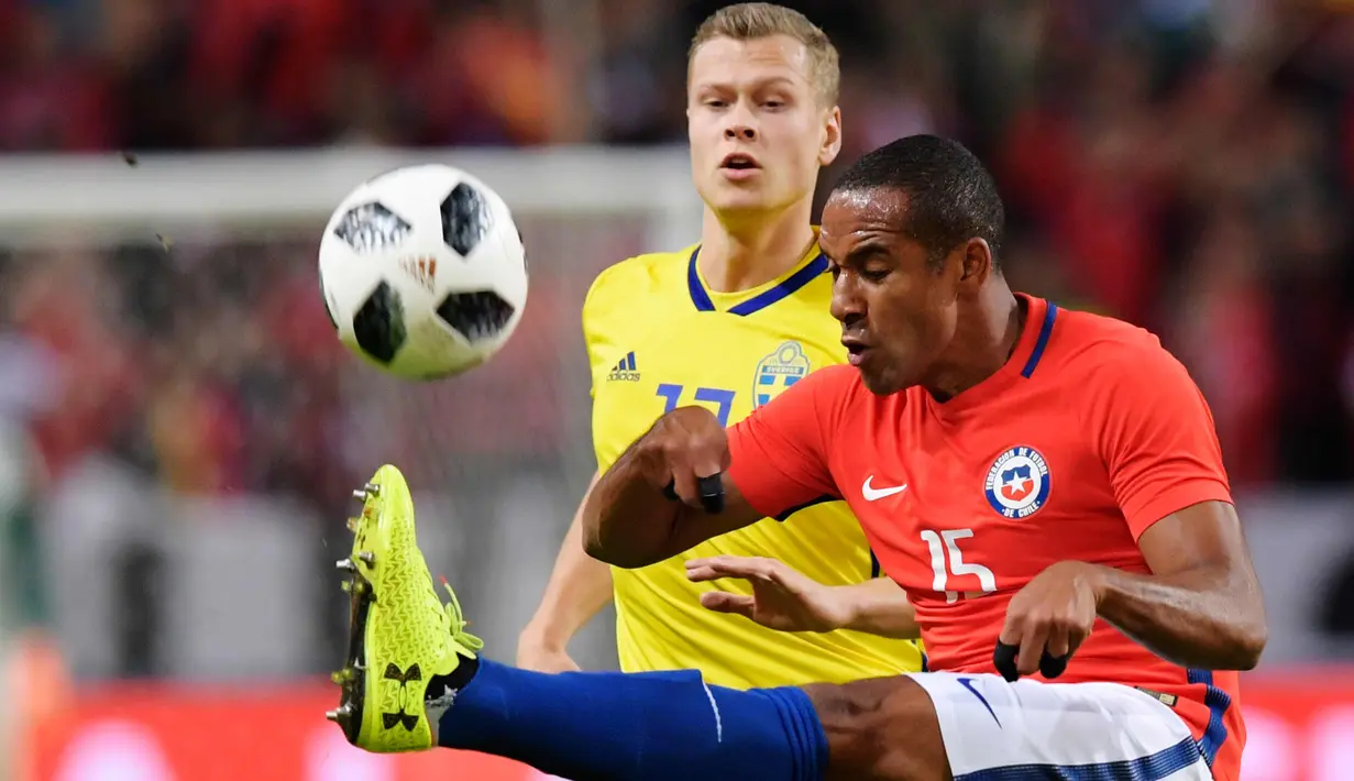Bek Chile, Jean Beausejour berusaha membuang bola dari kawalan gelandang Swedia, Viktor Claesson saat bertanding pada pertandingan persahabatan internasional Friends di Arena, Stockholm, (24/3). Chile menang 2-1 atas Swedia. (Anders Wiklund/TT via AP)