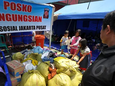 Sejumlah anak mencari pakaian layak pakai di posko pengungsian kebakaran di Kebon Melati, Tanah Abang, Jakarta, Jumat (6/3/2015). Kebakaran hebat pada Kamis (5/3) petang menyebabkan setidaknya 1.600 warga terpaksa mengungsi. ( Liputan6.com/Faizal Fanani)