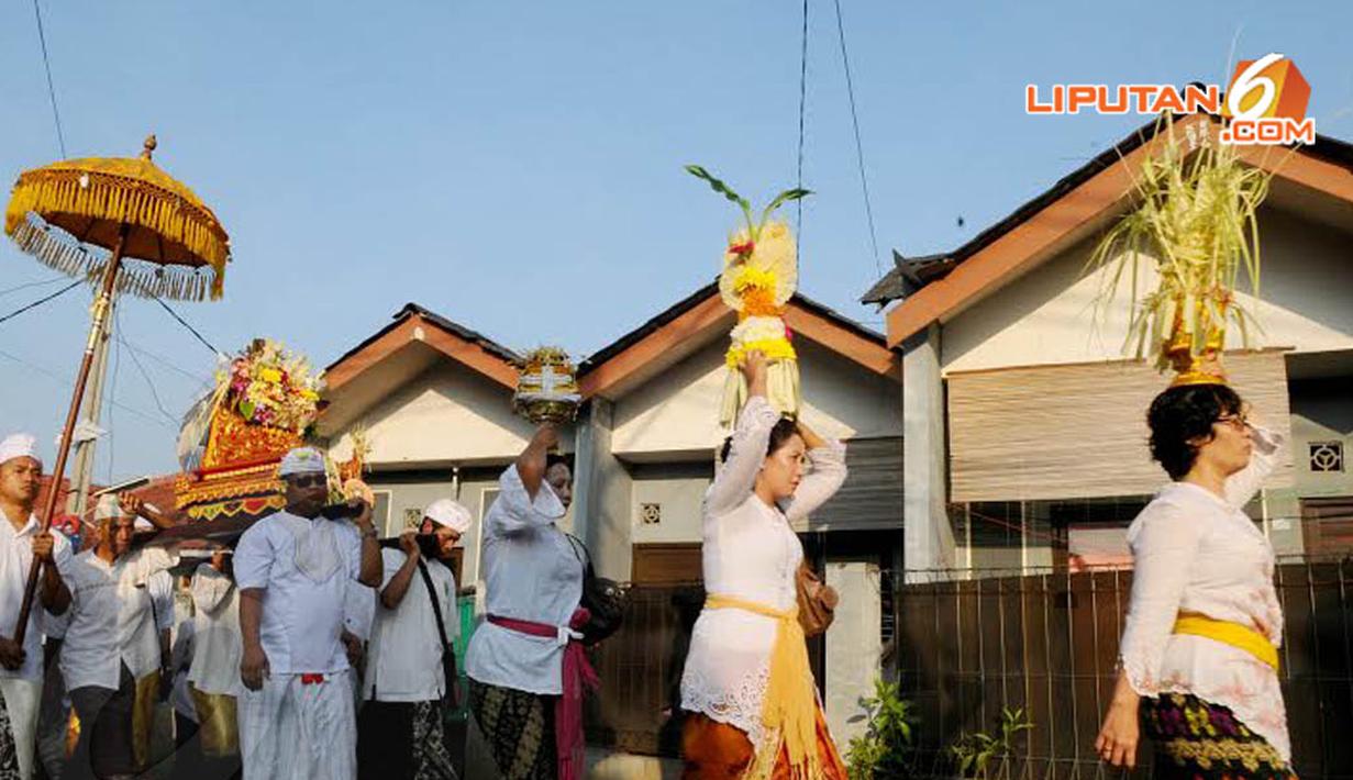 Dengan berpakaian adat khas Bali, tampak rombongan yang membawa sesaji untuk Upacara Melasti (Liputan6.com/Andrian M Tunay)