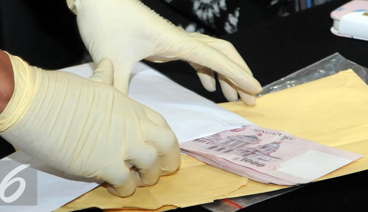 Barang bukti berupa uang dolar Singapura yang berhasil diamankan KPK saat OTT terhadap Panitera Pengganti PN Jakpus, Jakarta, Jumat (1/7). (Liputan6.com/Helmi Afandi)