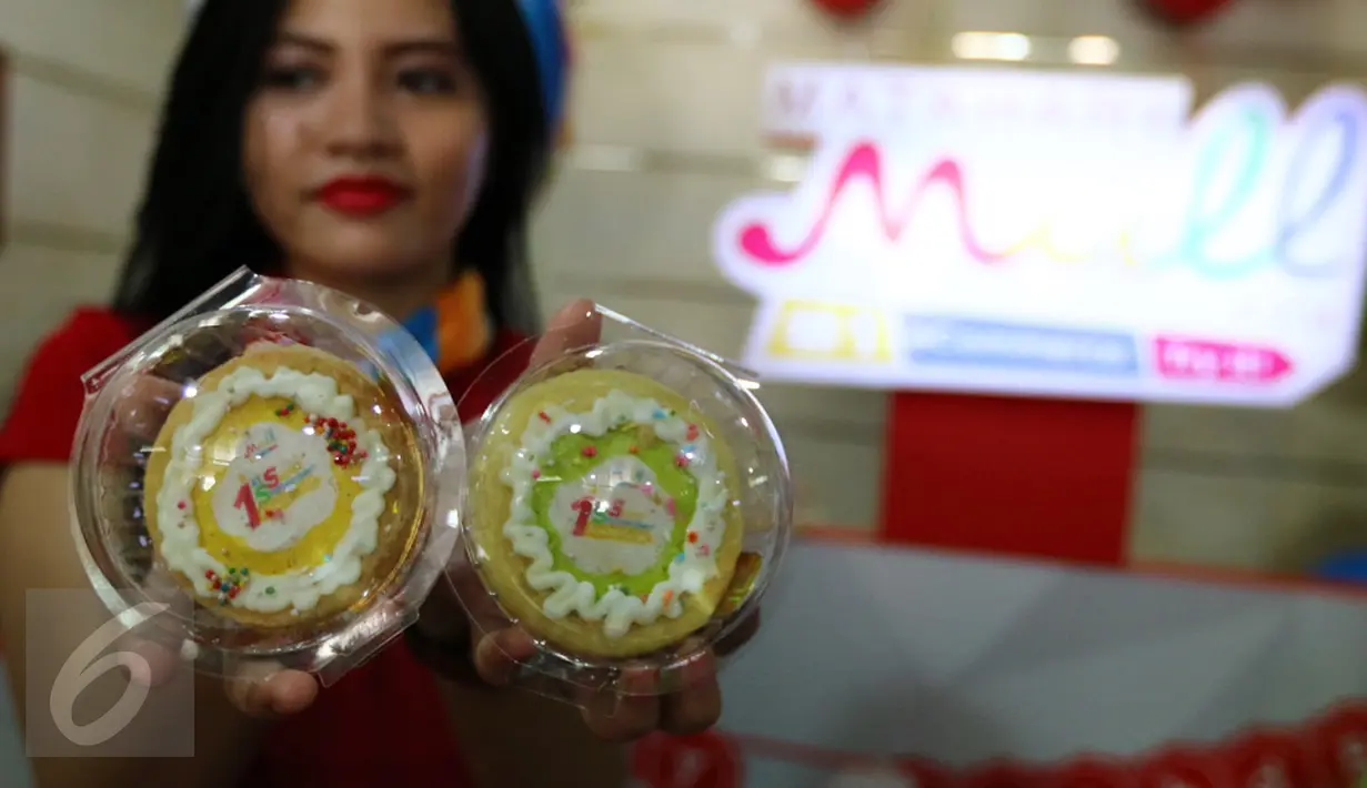 Seorang model menunjukkan kue yang akan dibagikan kepada para pelanggan pada Hari Pelanggan Nasional di Gajah Mada Plaza, Jakarta, Minggu (04/9). Melalui eKiosk, pelanggan diberikan kemudahan dan kenyamanan berbelanja online. (Liputan6.com/Fery Pradolo)