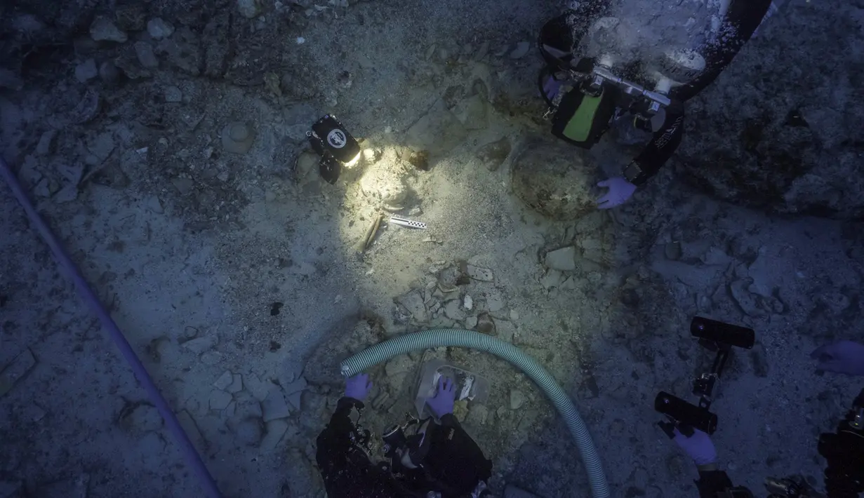 Tim arkeolog berada di samping sisa-sisa kerangka manusia yang ditemukan di dekat bangkai kapal era Romawi yang karam di perarian dekat Pulau Antikythera, Yunani, pada 6 September 2016. (Greek Ministry of Culture/Reuters)