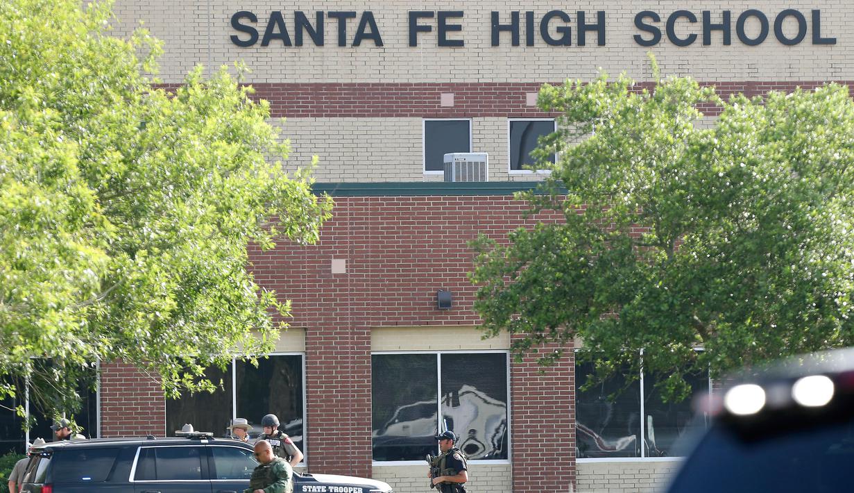 Aparat keamanan berlarian saat berusaha membekuk pelaku penembakan di Santa Fe High School, Texas, Amerika Serikat, Jumat (18/5). Aparat kepolisian menyebut mayoritas korban jiwa adalah para murid. (Steve Gonzales/Houston Chronicle via AP)